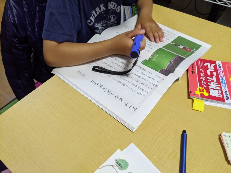 タッチペン読み上げで教科書の勉強をするむすこ